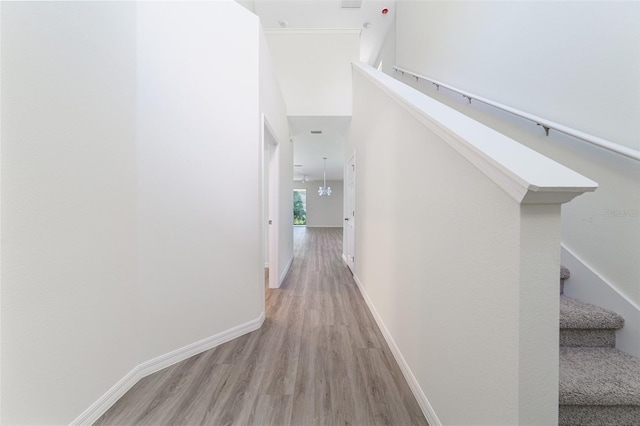 hall featuring a high ceiling, stairway, wood finished floors, and baseboards