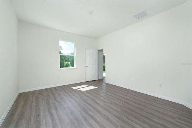 spare room featuring visible vents, baseboards, and wood finished floors