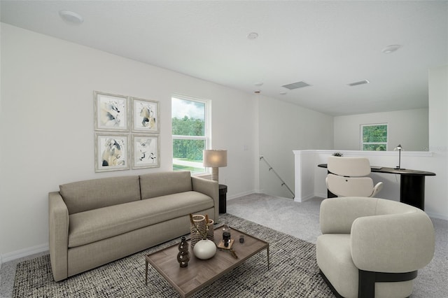 living room featuring a healthy amount of sunlight, carpet floors, baseboards, and visible vents