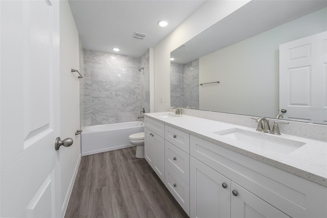 bathroom featuring double vanity, wood finished floors, a sink, and visible vents