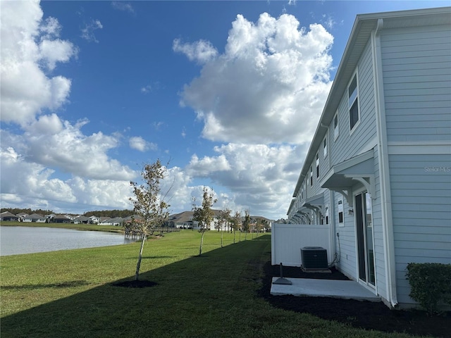 view of yard with central AC unit and a water view