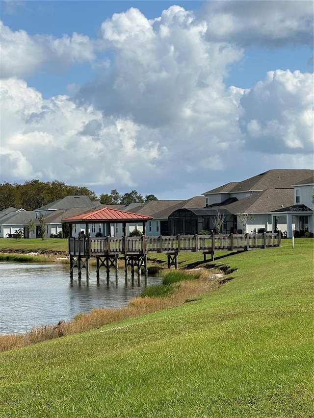 view of property's community with a water view and a yard