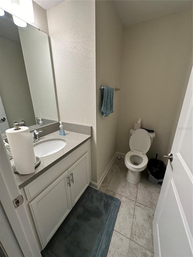 bathroom with vanity, tile patterned floors, and toilet