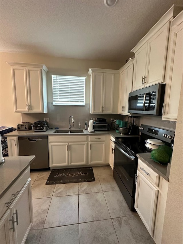 kitchen featuring stainless steel appliances, white cabinetry, sink, and a textured ceiling