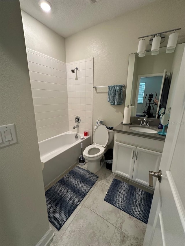 full bathroom with toilet, tile patterned flooring, a textured ceiling, tiled shower / bath combo, and vanity