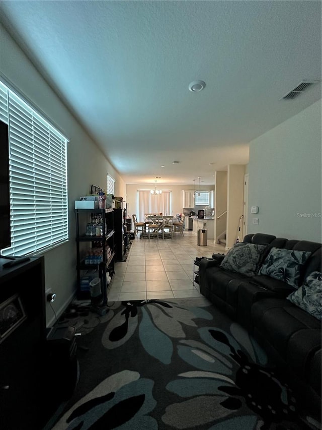 living room featuring a notable chandelier and light tile patterned flooring