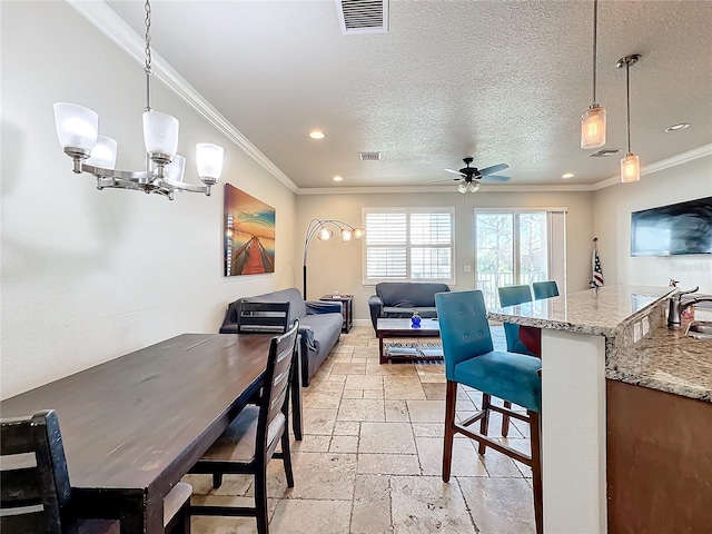 dining space featuring ornamental molding, ceiling fan with notable chandelier, a textured ceiling, and sink