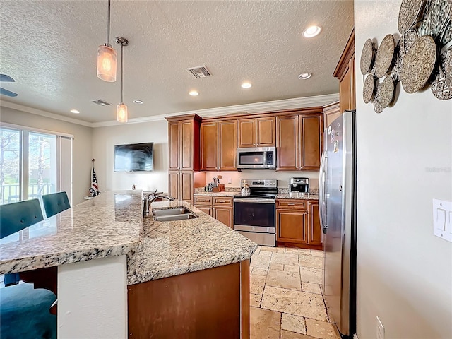 kitchen with stainless steel appliances, sink, a large island with sink, a breakfast bar area, and pendant lighting