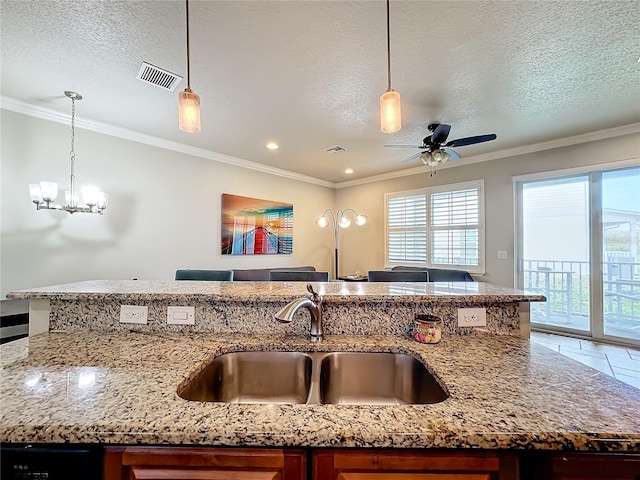 kitchen featuring ornamental molding, sink, decorative light fixtures, and light stone countertops