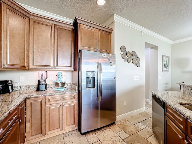 kitchen with light stone countertops, appliances with stainless steel finishes, a textured ceiling, and ornamental molding