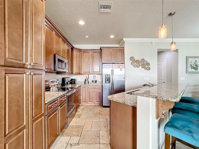 kitchen featuring a kitchen island, appliances with stainless steel finishes, light stone counters, and a breakfast bar area