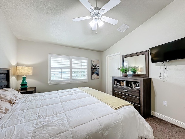 bedroom with carpet, a textured ceiling, lofted ceiling, and ceiling fan