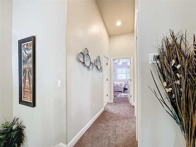 corridor featuring carpet flooring and high vaulted ceiling