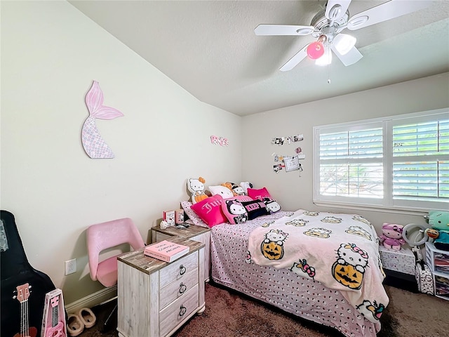 bedroom with ceiling fan, a textured ceiling, and dark carpet