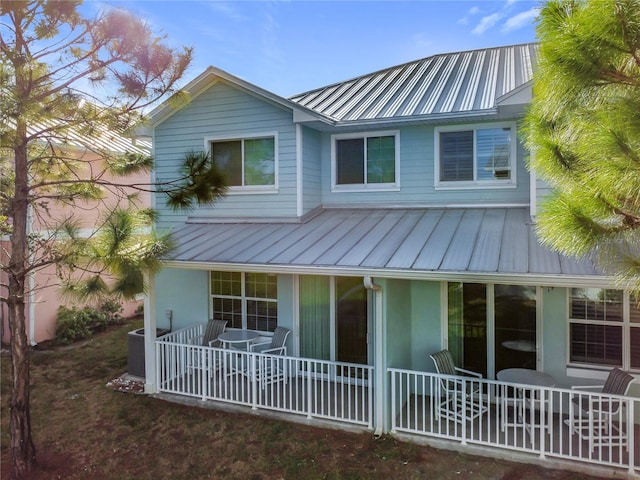 rear view of property with central AC