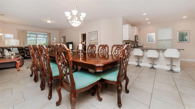 tiled dining room featuring a chandelier