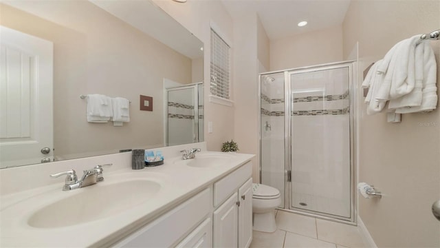 bathroom with toilet, vanity, tile patterned flooring, and a shower with shower door