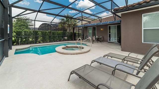 view of pool featuring glass enclosure, a patio, and an in ground hot tub