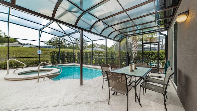 view of pool with a patio, glass enclosure, and an in ground hot tub