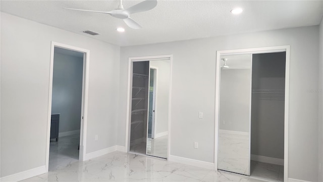 unfurnished bedroom featuring ceiling fan, a spacious closet, a textured ceiling, and a closet