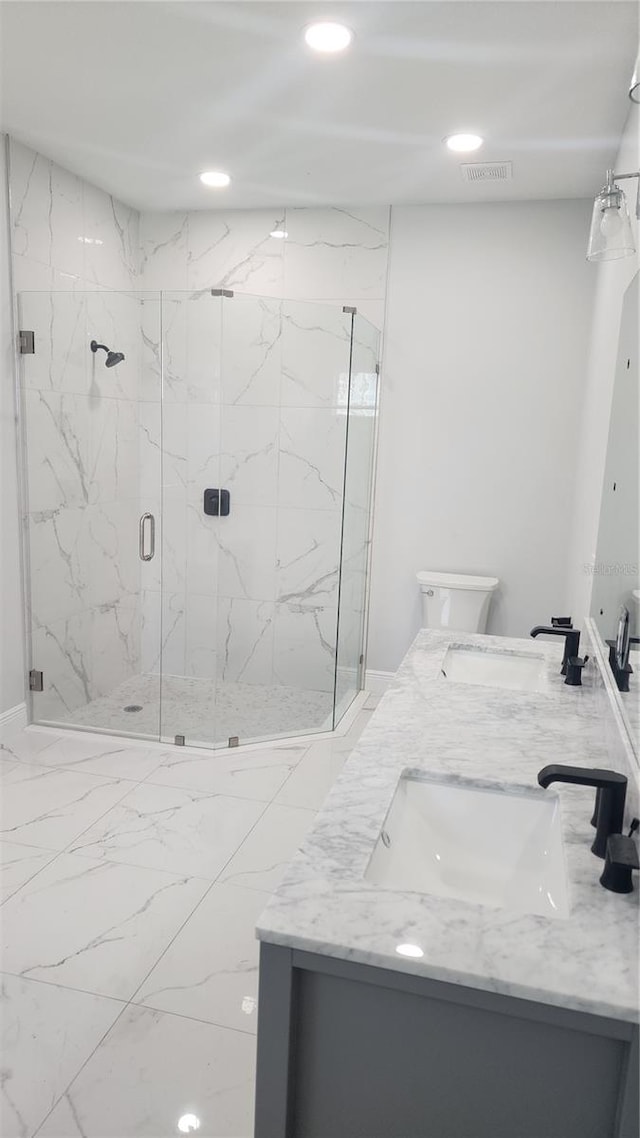 bathroom featuring vanity, an enclosed shower, and toilet