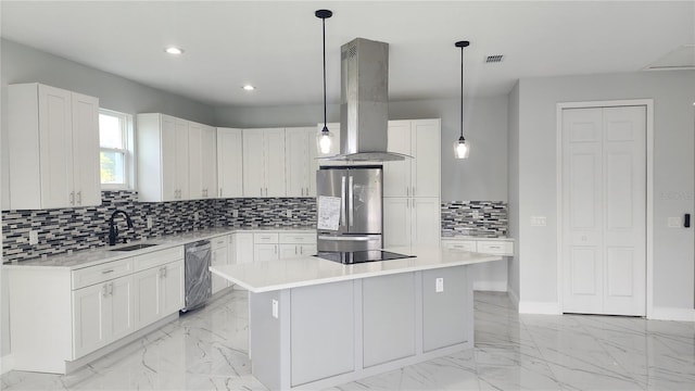 kitchen featuring stainless steel appliances, sink, pendant lighting, a center island, and white cabinetry