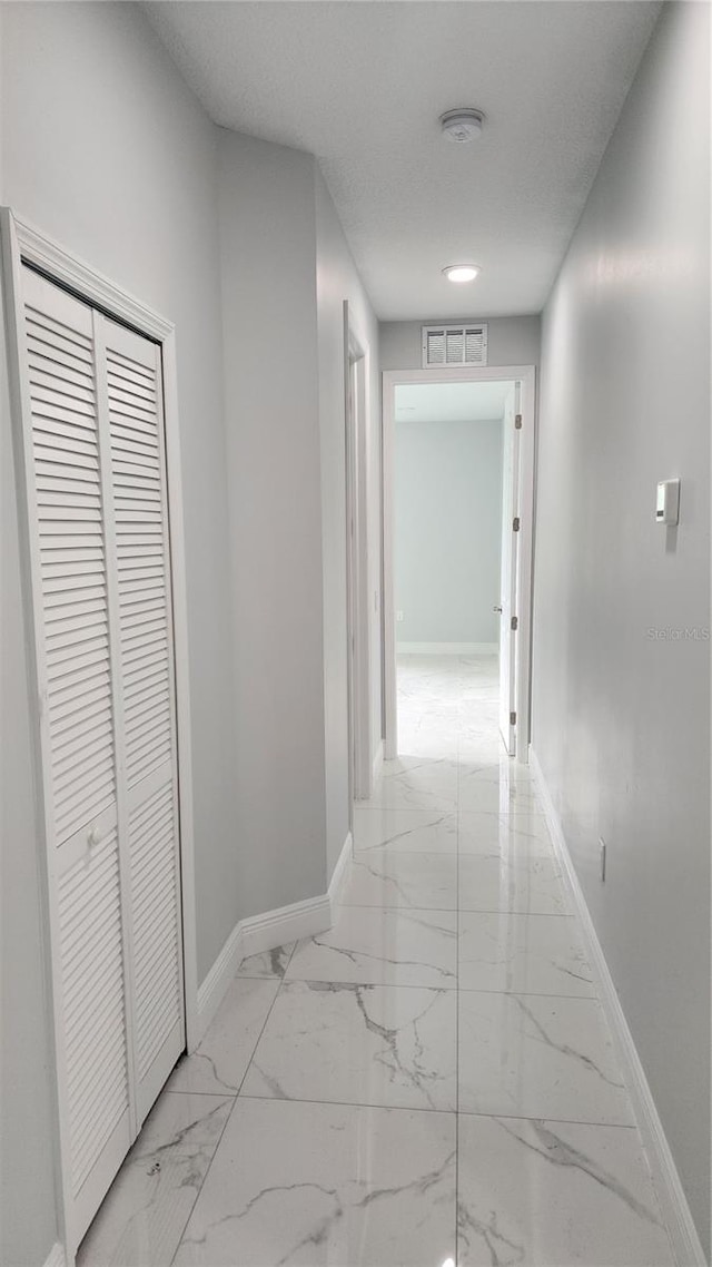 hallway with a textured ceiling