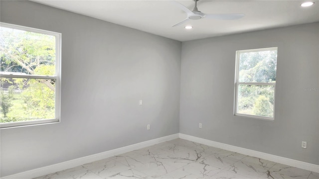 spare room featuring ceiling fan and plenty of natural light