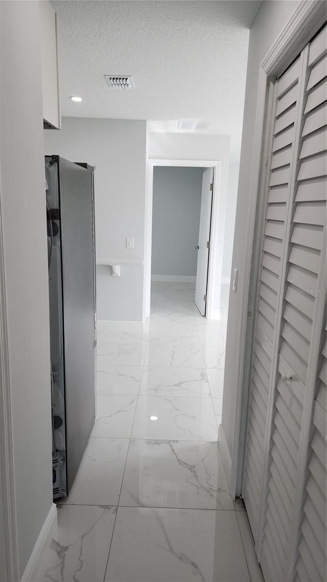 hallway with a textured ceiling