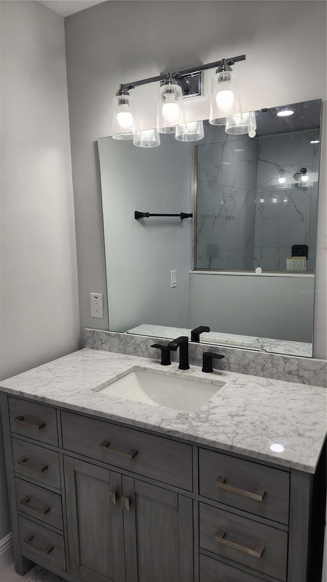 bathroom with vanity and tiled shower