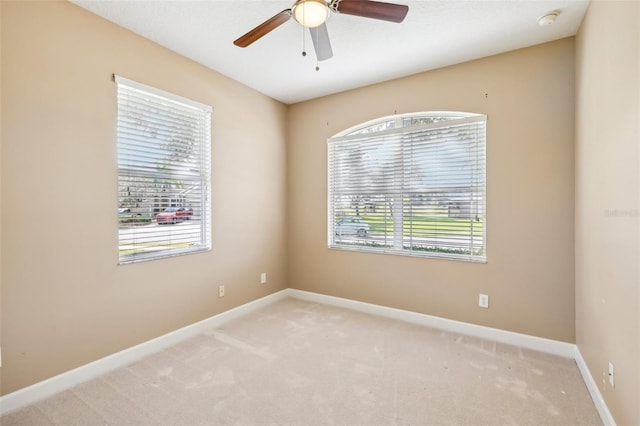 carpeted spare room with ceiling fan