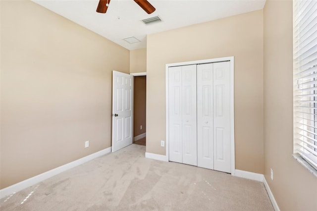 unfurnished bedroom with light carpet, a closet, multiple windows, and ceiling fan