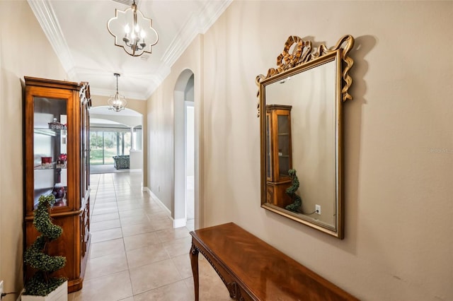 hallway featuring light tile patterned flooring, crown molding, and a chandelier