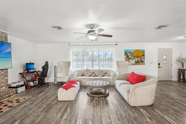 living room with dark wood-type flooring, ceiling fan, and a textured ceiling