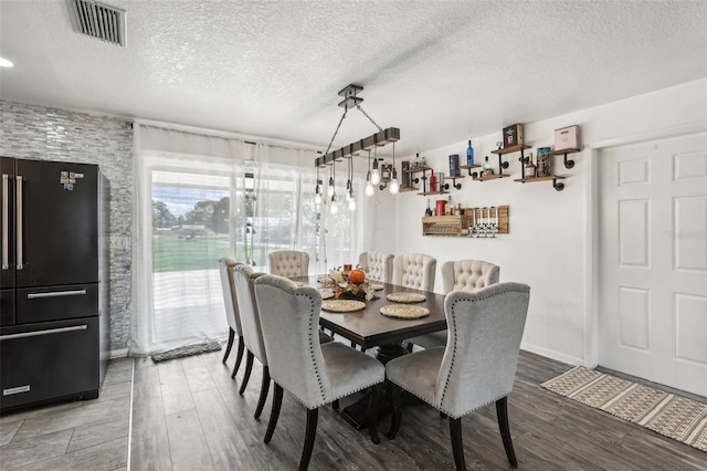 dining room with hardwood / wood-style floors and a textured ceiling