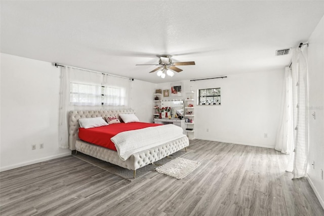 bedroom featuring a textured ceiling, hardwood / wood-style floors, and ceiling fan