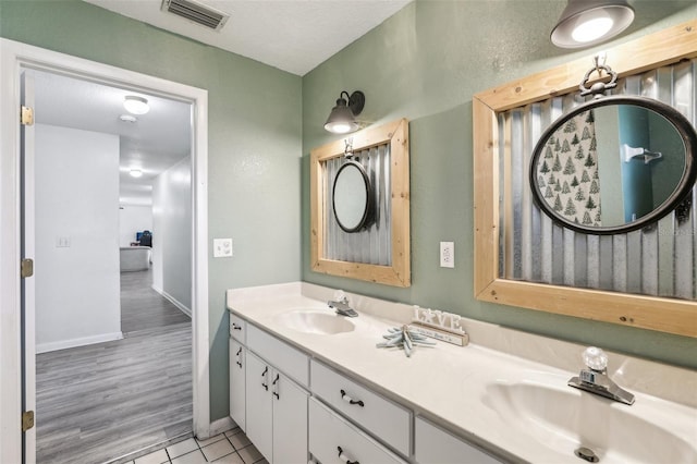 bathroom with wood-type flooring, a textured ceiling, and vanity