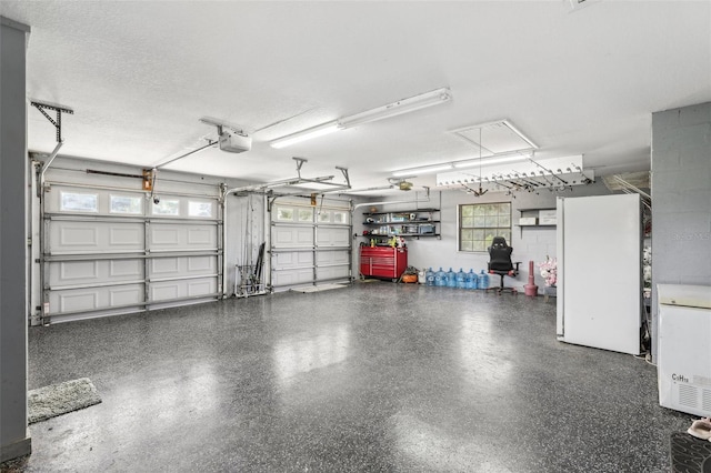 garage with a garage door opener and white refrigerator