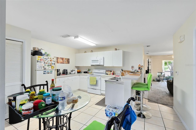 kitchen with white cabinetry, white appliances, and light tile patterned flooring