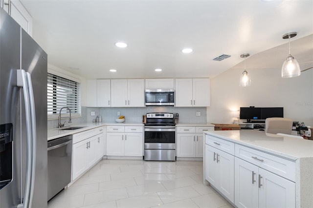 kitchen with hanging light fixtures, sink, decorative backsplash, appliances with stainless steel finishes, and white cabinetry