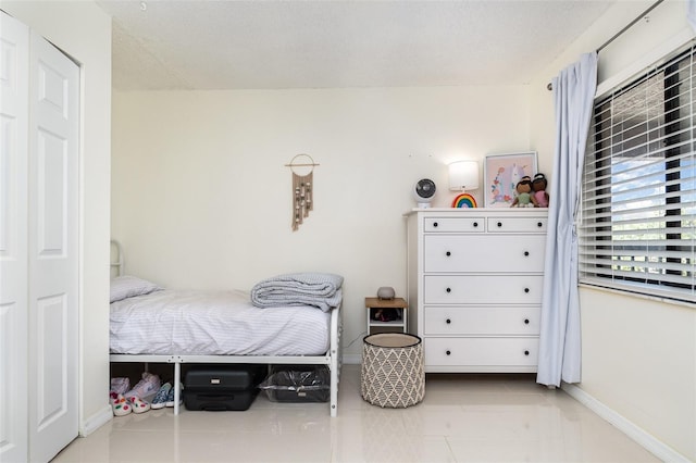 bedroom featuring light tile patterned floors and a textured ceiling