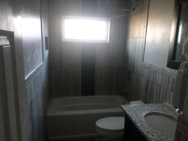 5900 Judy Dee Dr, Orlando, FL 32808 - bathroom featuring toilet, bathing tub / shower combination, vanity, and tile walls