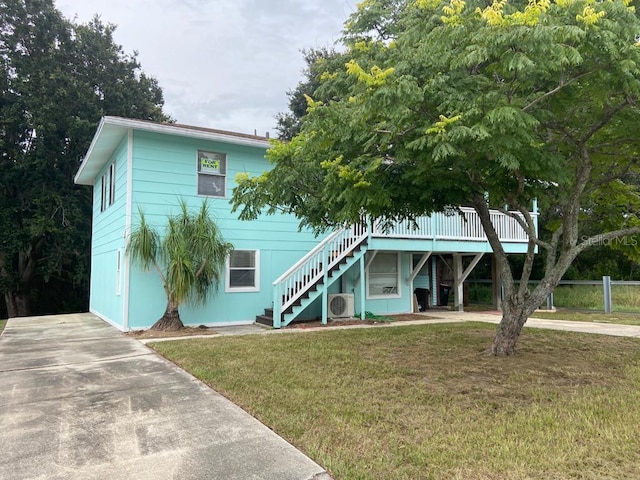 view of front facade with a carport, ac unit, and a front lawn