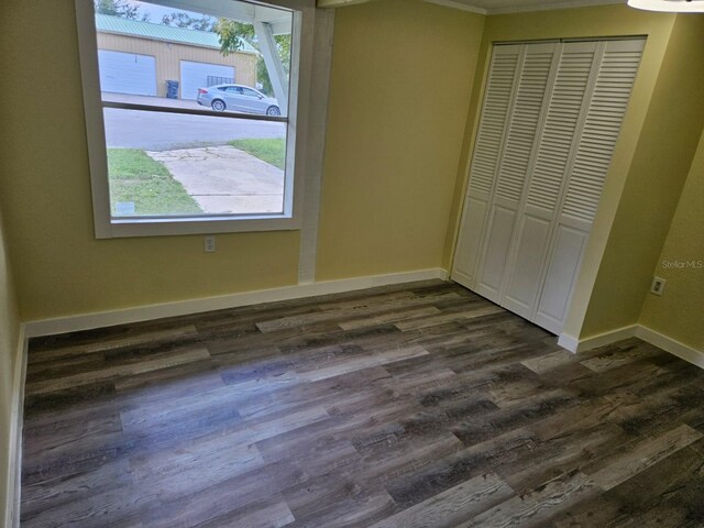 unfurnished bedroom featuring dark hardwood / wood-style floors and a closet