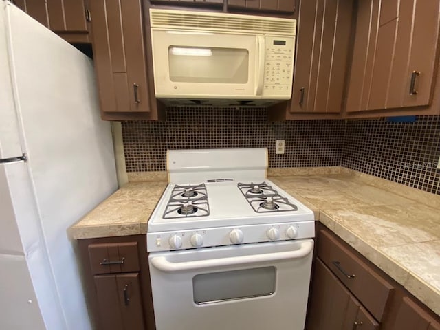 kitchen featuring decorative backsplash and white appliances