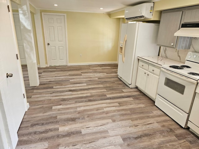 kitchen featuring light hardwood / wood-style floors, a wall unit AC, white appliances, and extractor fan