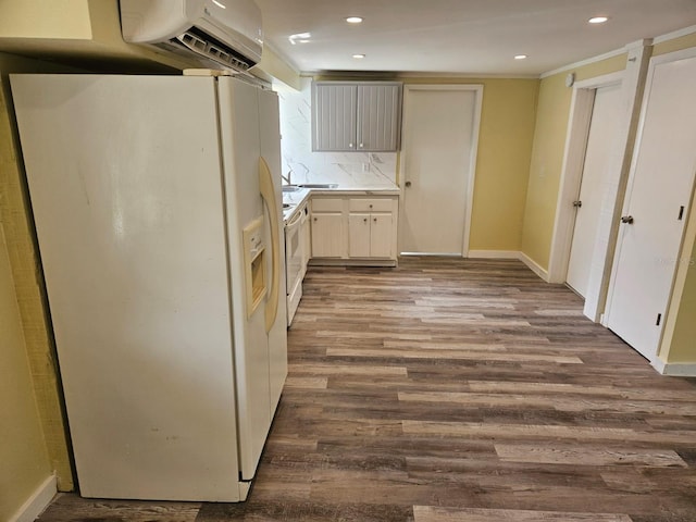 kitchen with a wall mounted air conditioner, white appliances, backsplash, ornamental molding, and wood-type flooring