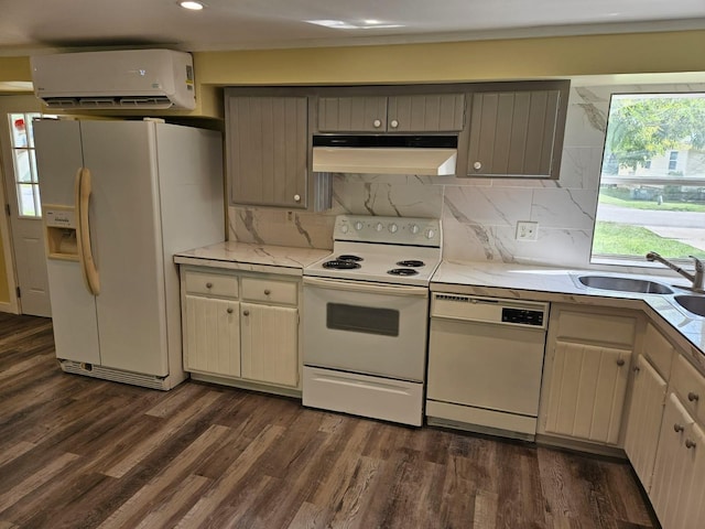 kitchen with a wall mounted air conditioner, dark hardwood / wood-style floors, white appliances, and backsplash