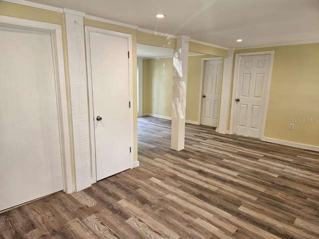 basement with crown molding and dark wood-type flooring