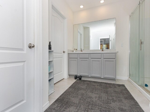 bathroom featuring tile patterned floors, a shower with door, and vanity